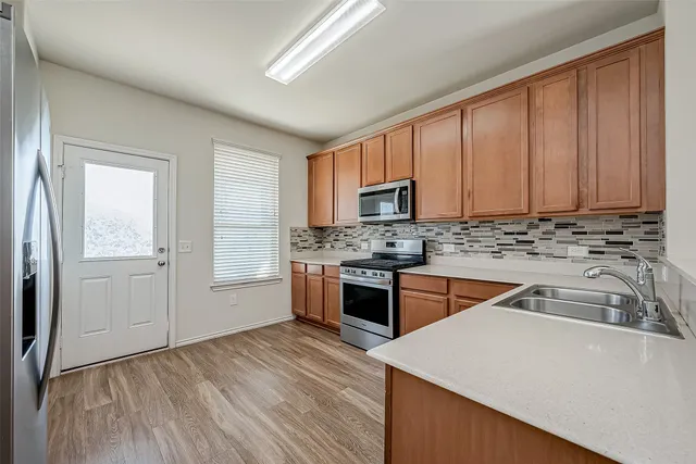 a kitchen with granite countertop a stove top oven sink and cabinets