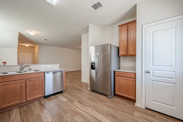 a kitchen with stainless steel appliances granite countertop a refrigerator and a sink