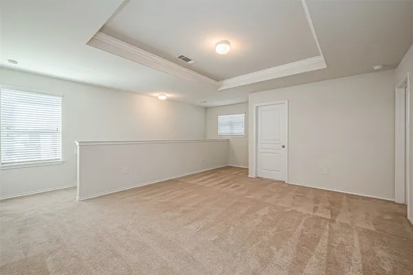 an empty room with windows and refrigerator