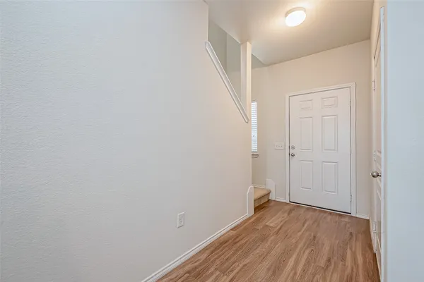 a view of a room with wooden floor and white doors
