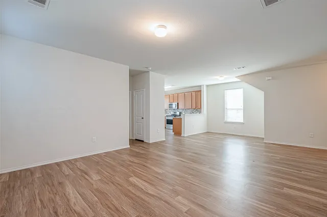 a view of empty room with wooden floor and windows