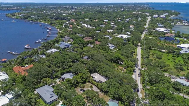 an aerial view of residential houses with outdoor space and trees