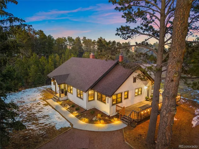 a view of a white house with a yard table and chairs