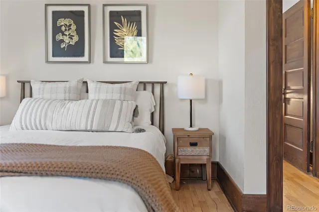 a bed room with a bed and a painting on the wall