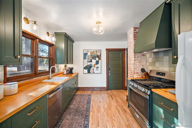 a large kitchen with stainless steel appliances granite countertop a lot of counter space and a sink