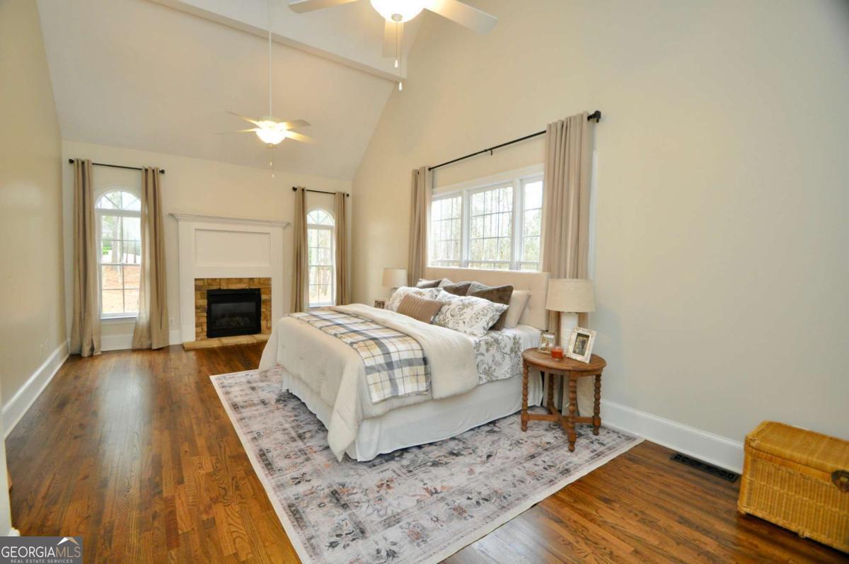 1070 Lexington Court Bishop, GA 30621 - Photo 24 of 67 a spacious bedroom with a bed and wooden floor