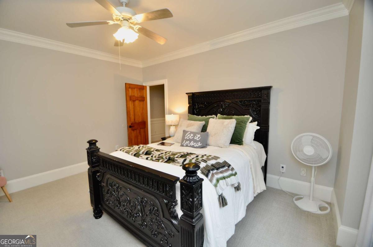 1070 Lexington Court Bishop, GA 30621 - Photo 35 of 67 a spacious bedroom with a bed and a chandelier