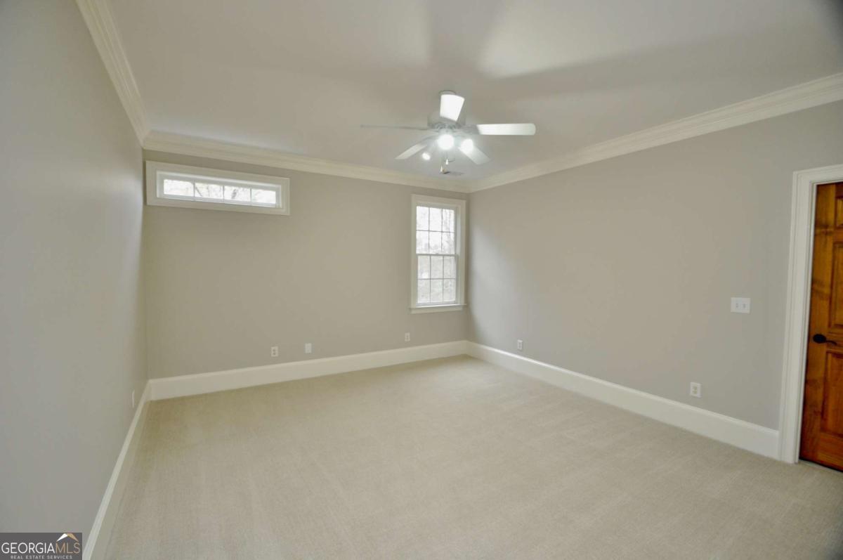 1070 Lexington Court Bishop, GA 30621 - Photo 45 of 67 an empty room with a chandelier fan and windows