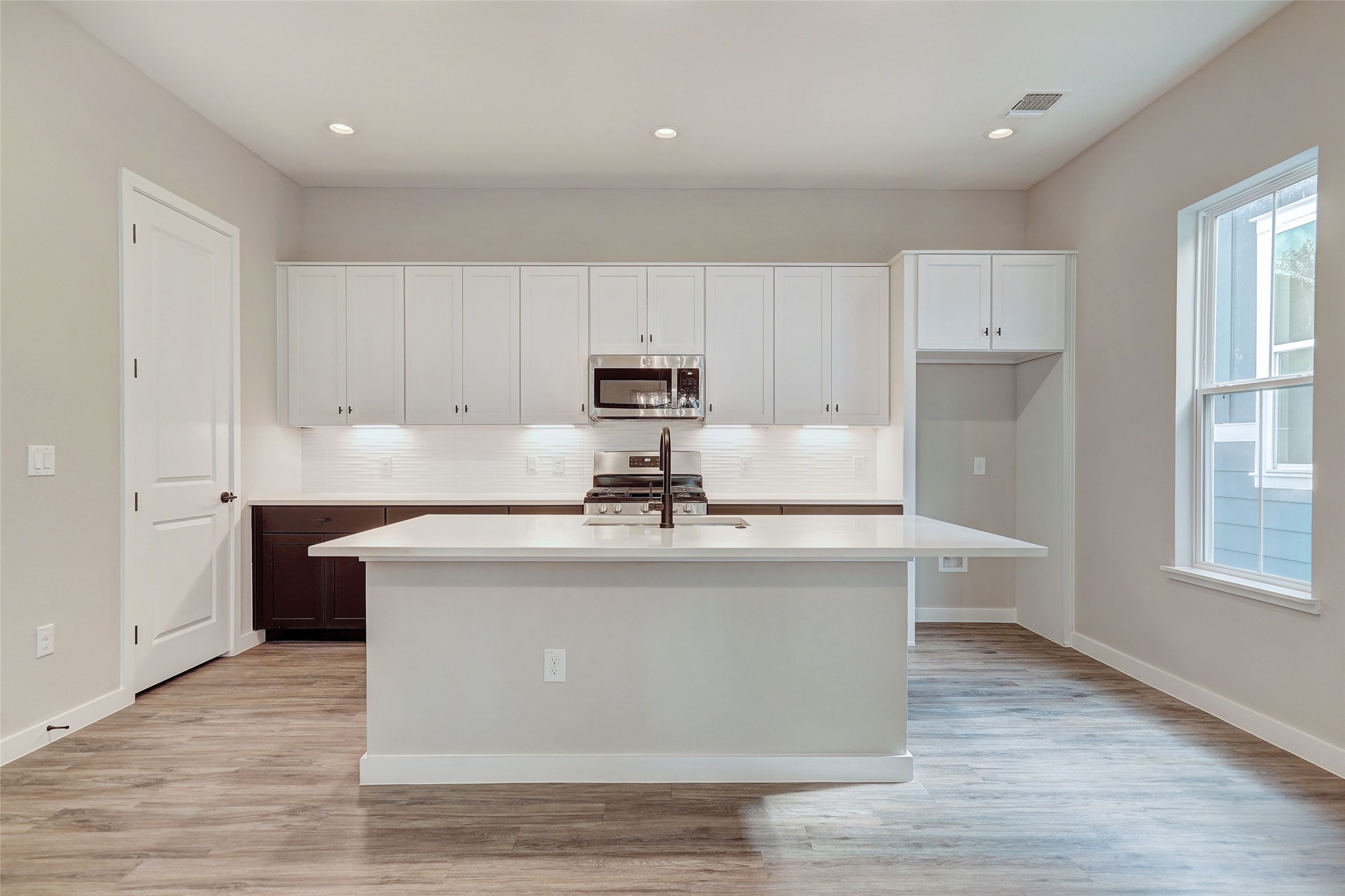 3809 Valley View Road, Unit 13 Austin, TX 78704 - Photo 8 of 27 a kitchen with kitchen island a sink a stove a refrigerator and white cabinets