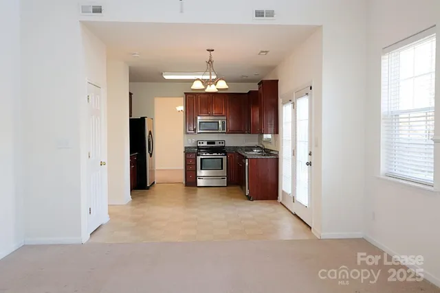 a view of a kitchen with a sink a refrigerator and window