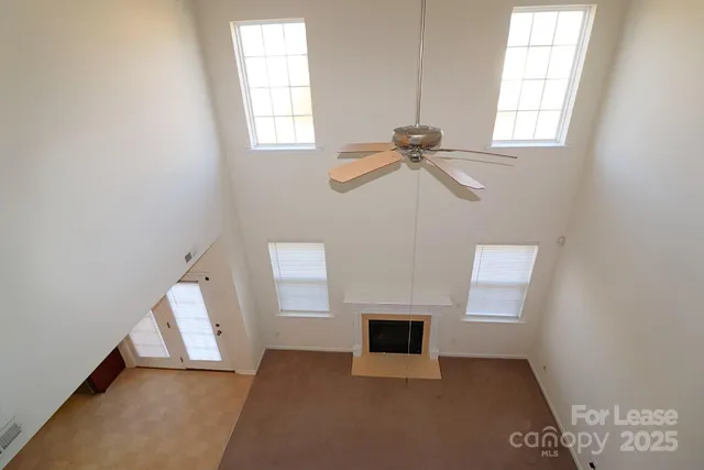 an empty room with windows and fireplace