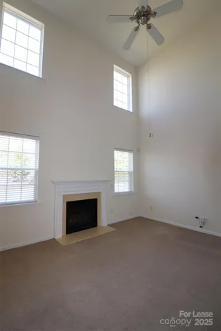 an empty room with a fireplace and windows