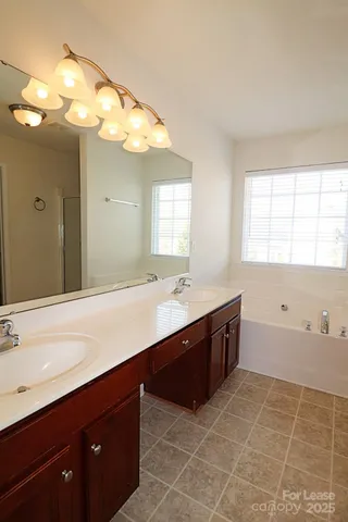 a spacious bathroom with a sink mirror and a bathtub