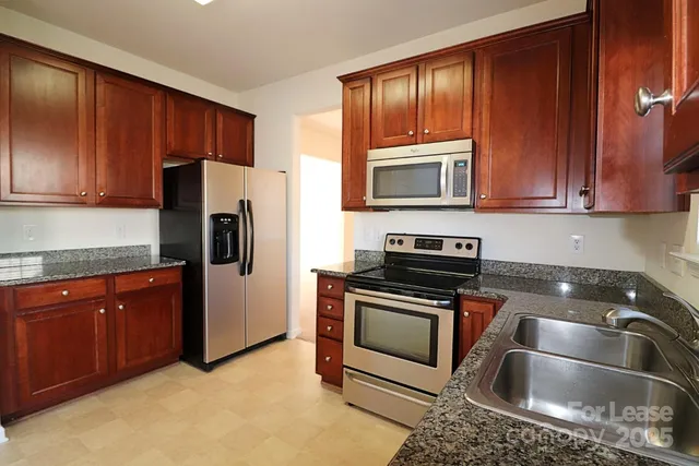 a kitchen with stainless steel appliances granite countertop a refrigerator stove a sink and dishwasher