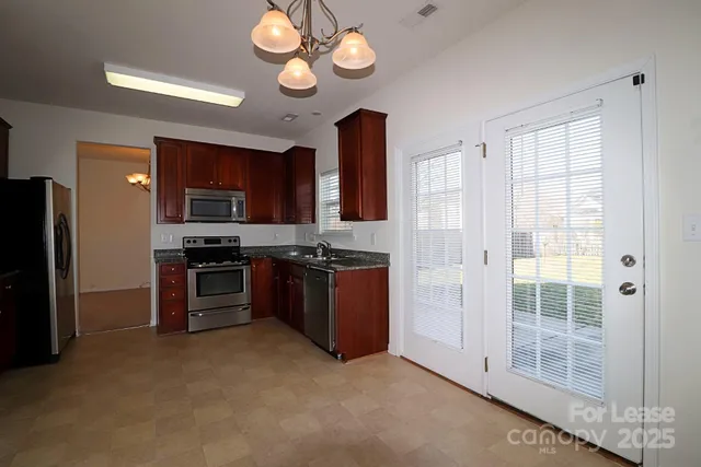 a large kitchen with cabinets and stainless steel appliances
