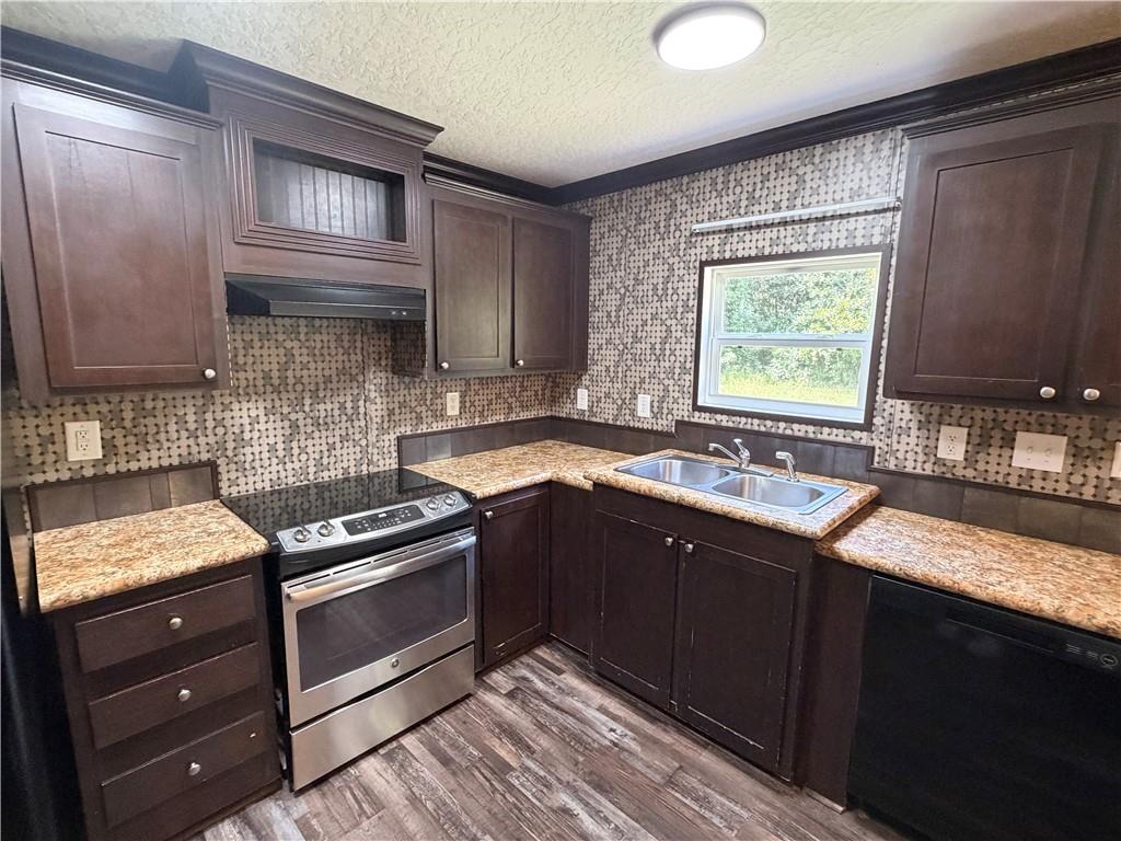 158 Kite Road Pittsview, AL 36871 - Photo 10 of 32 Kitchen featuring dark wood-finish cabinetry, light speckled countertops, and a full tile backsplash