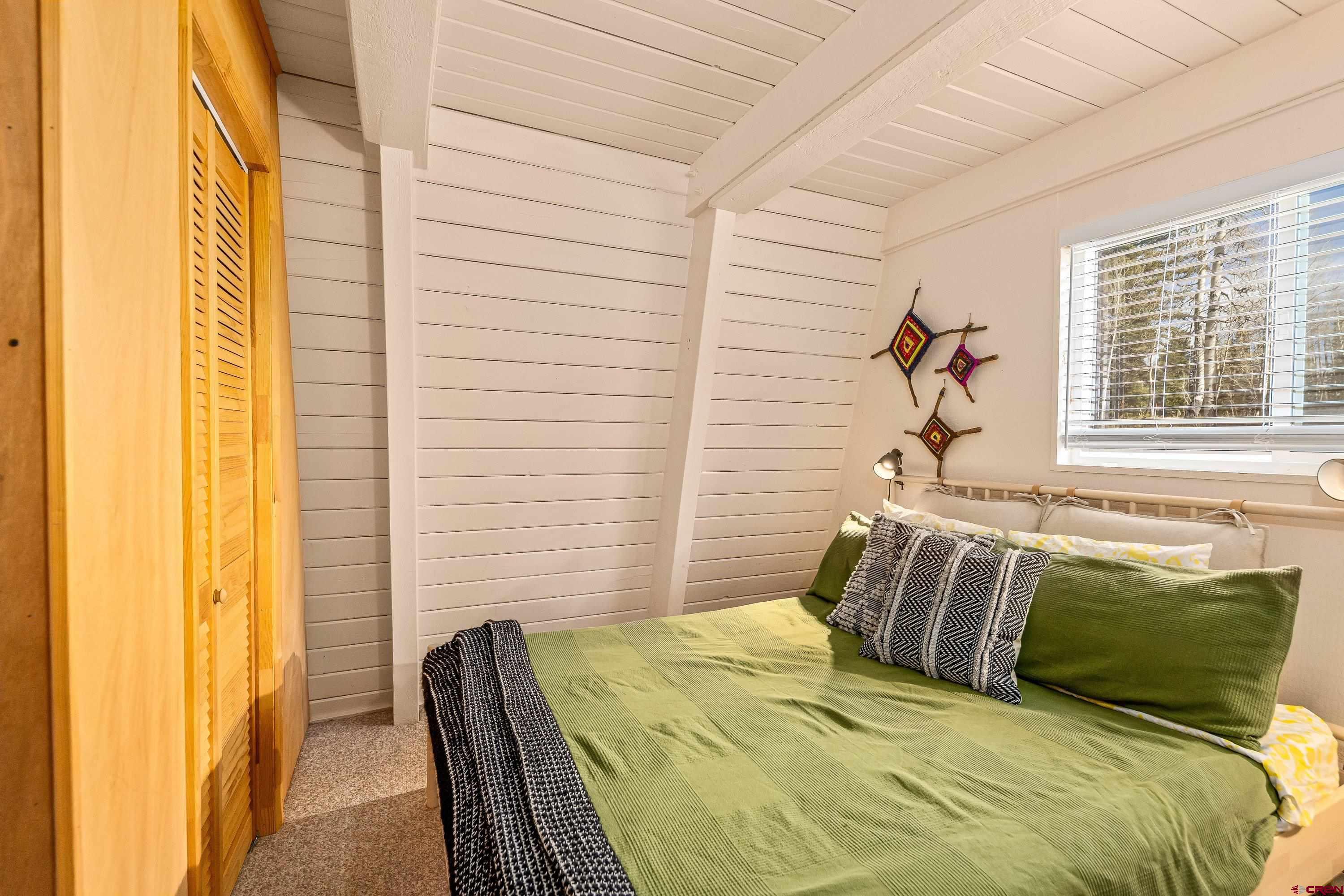 771 Spruce Road Cimarron, CO 81220 - Photo 7 of 34 a bed sitting in a bedroom next to a window