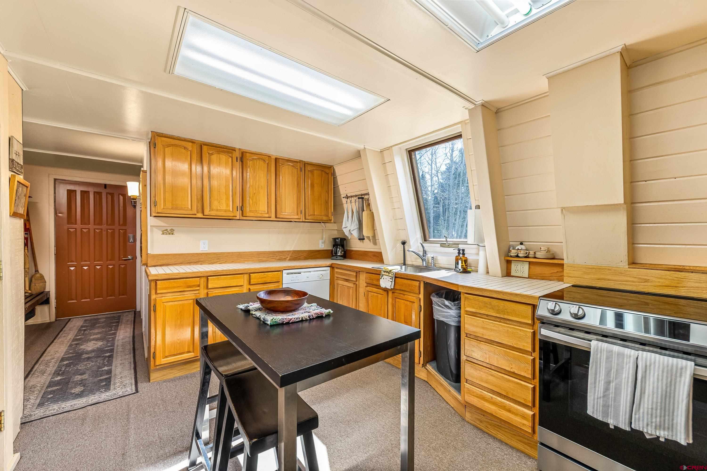 771 Spruce Road Cimarron, CO 81220 - Photo 10 of 34 a kitchen with stainless steel appliances granite countertop a stove a sink dishwasher and cabinets with wooden floor