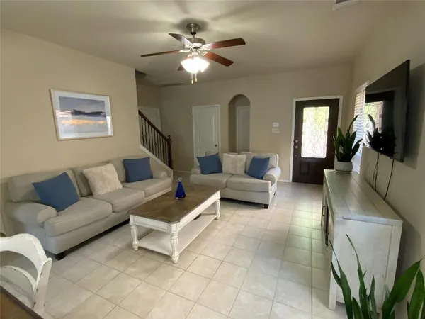 a living room with furniture a flat screen tv and kitchen view