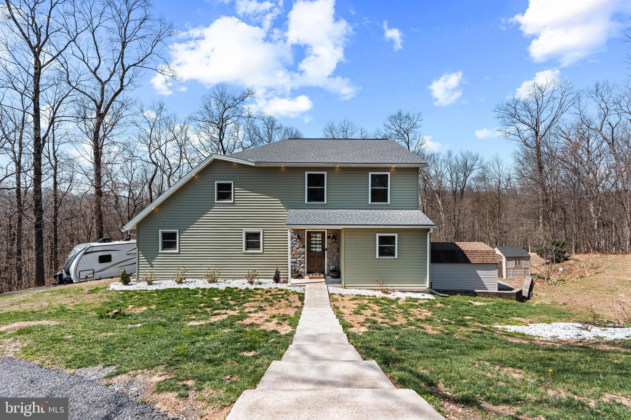 a front view of house with yard and trees in the background
