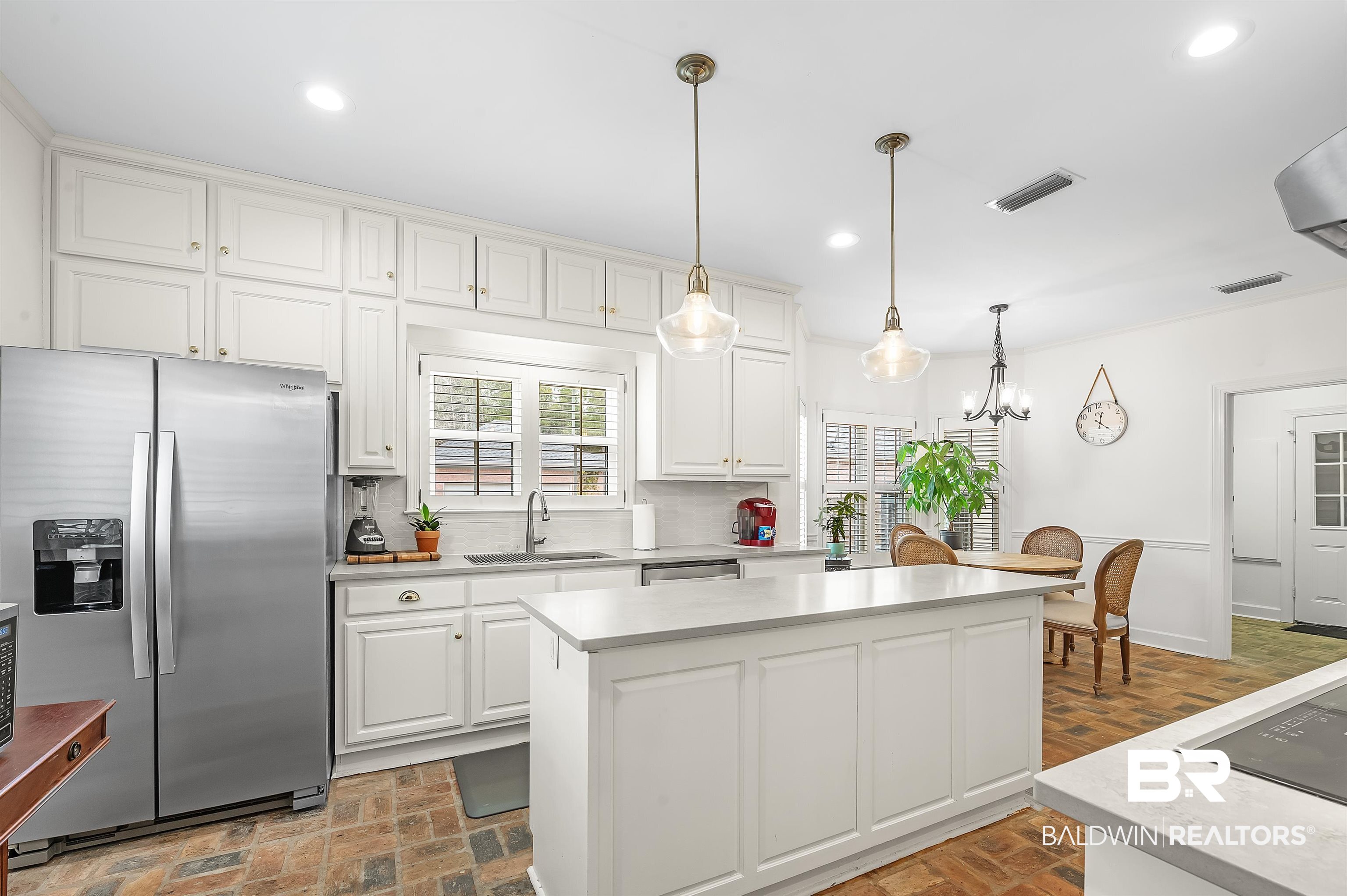 8915 Bay Point Drive Elberta, AL 36530 - Photo 44 of 74 Kitchen featuring brick floor, recessed lighting, stainless steel appliances, a sink, and white cabinetry