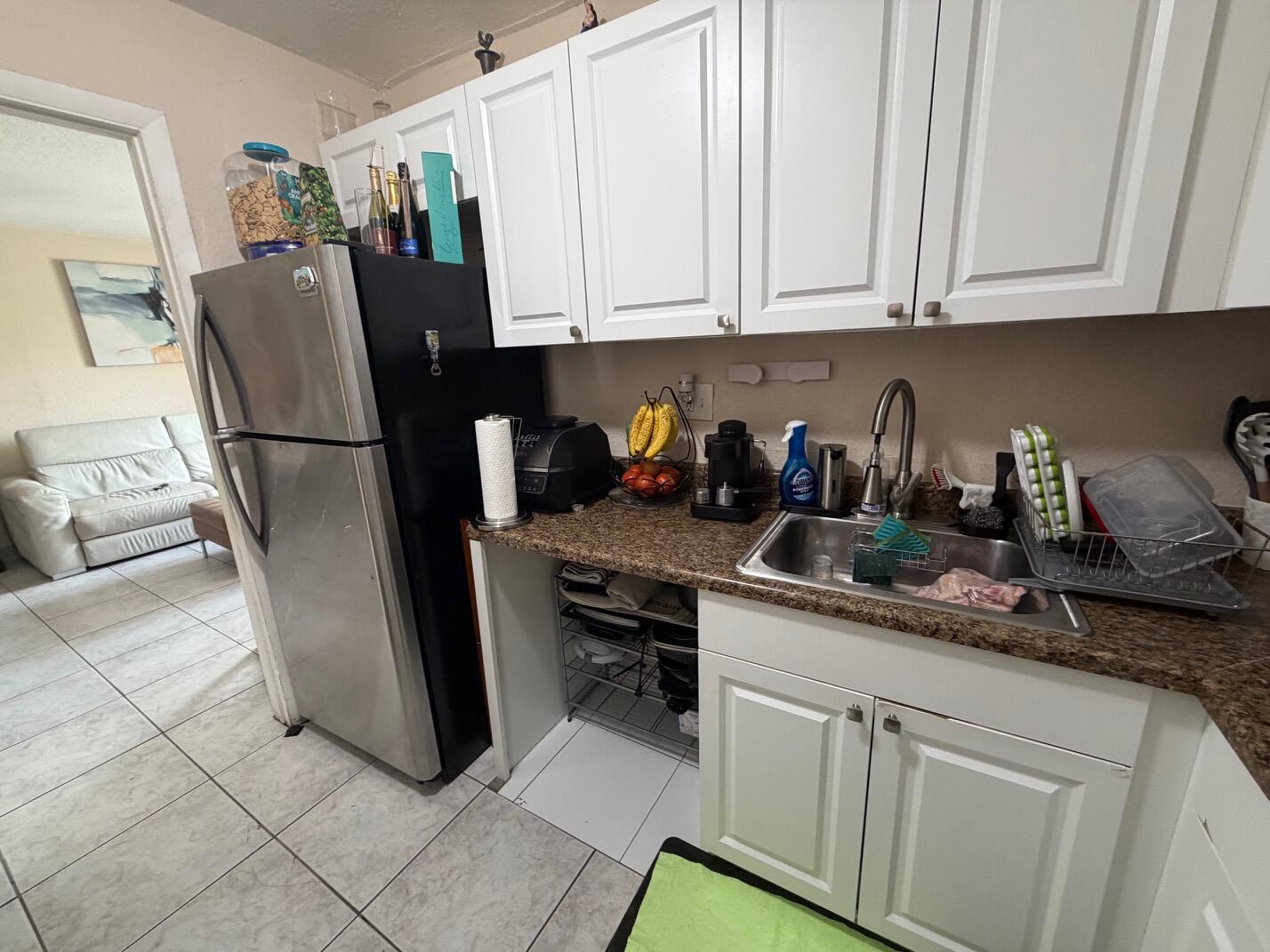4841 Northwest 7th Street, Unit 3084 Miami, FL 33126 - Photo 21 of 29 a kitchen with stainless steel appliances granite countertop a refrigerator sink and cabinets