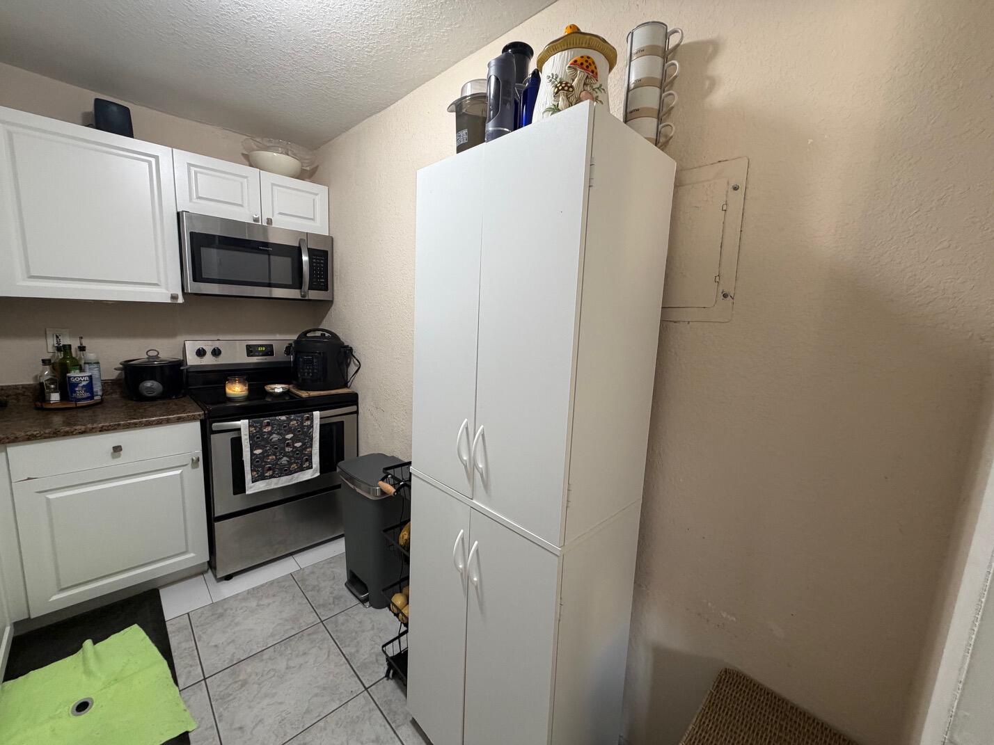 4841 Northwest 7th Street, Unit 3084 Miami, FL 33126 - Photo 22 of 29 a kitchen with a refrigerator and a stove top oven