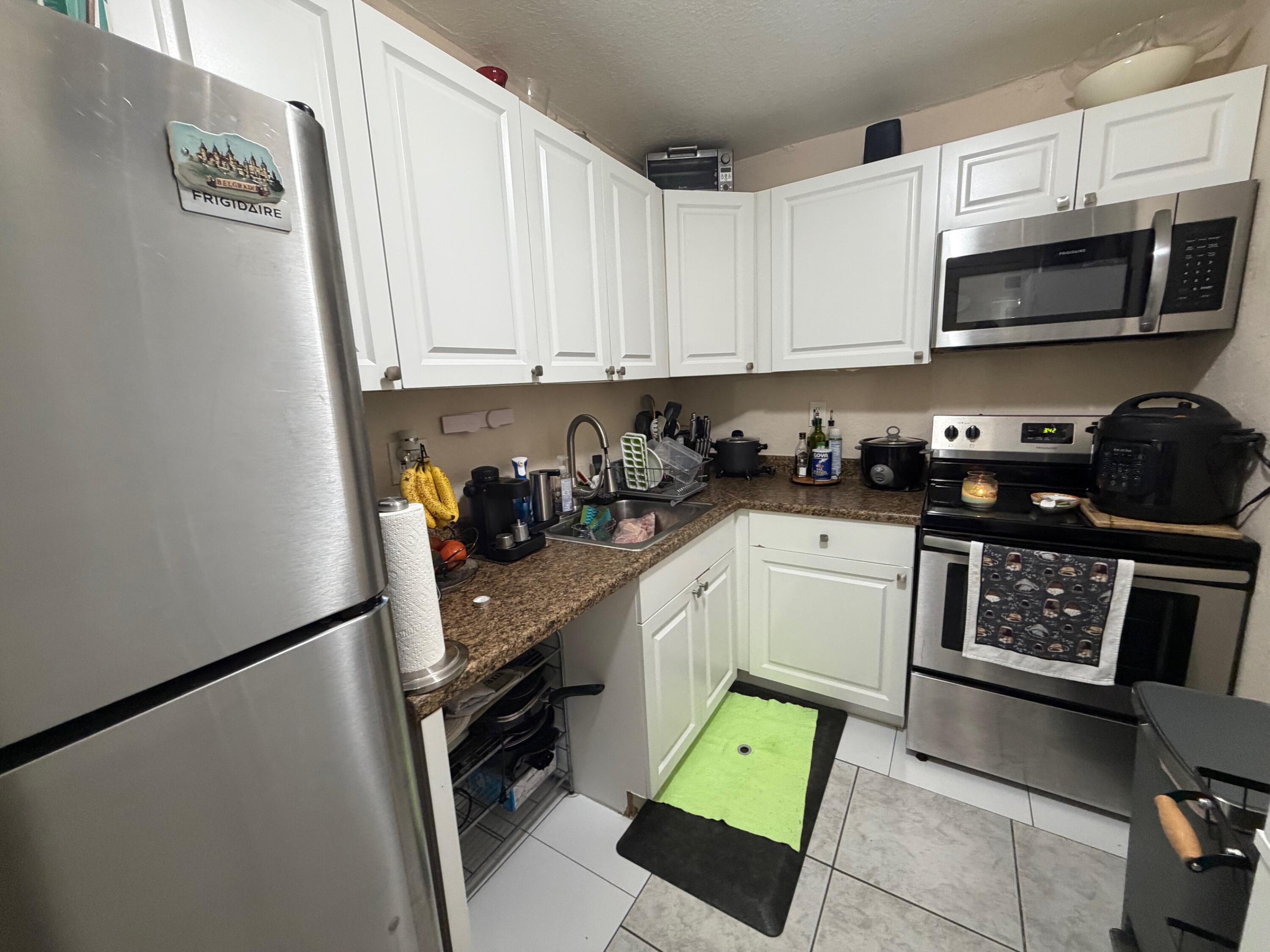 4841 Northwest 7th Street, Unit 3084 Miami, FL 33126 - Photo 4 of 29 a kitchen with stainless steel appliances a stove a sink and a refrigerator