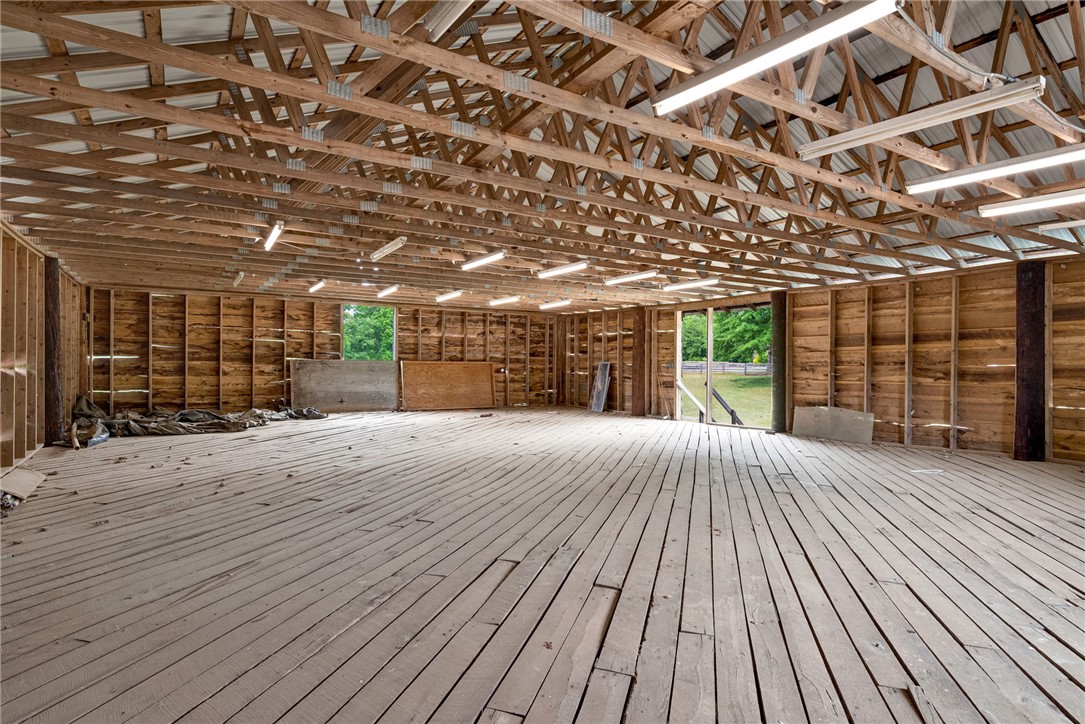 433 Latham Road Easley, SC 29640 - Photo 10 of 50 A spacious barn interior features exposed wooden beams and sturdy plank flooring, ready for various uses.