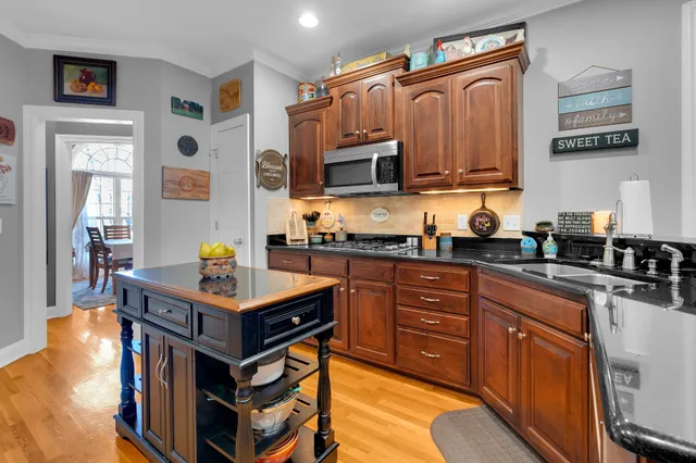a kitchen with stainless steel appliances granite countertop a sink a stove and refrigerator
