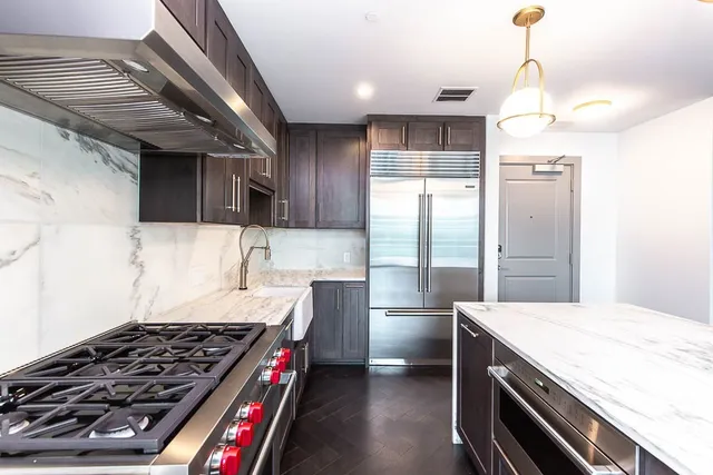 a kitchen with granite countertop a stove and a refrigerator