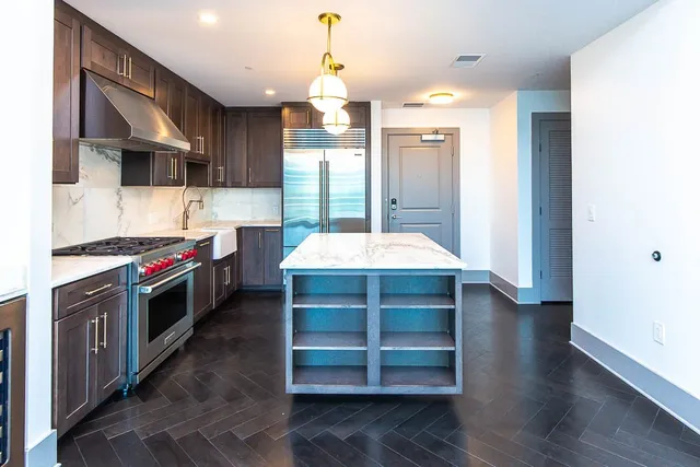 a large kitchen with stainless steel appliances a stove and a refrigerator