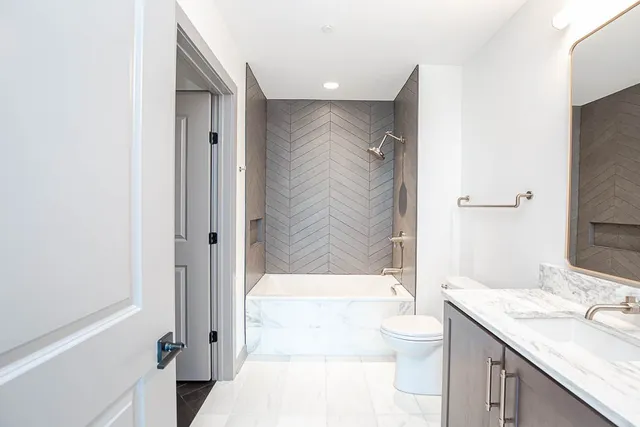 a bathroom with a granite countertop sink toilet and shower