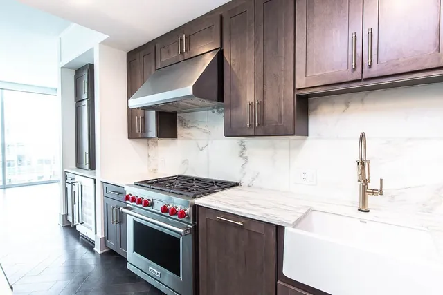 a kitchen with stainless steel appliances granite countertop a sink and a stove