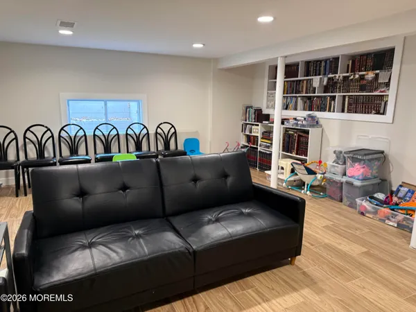 a living room with furniture a bookshelf and a window
