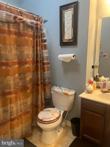 a bathroom with a toilet and a shower curtain