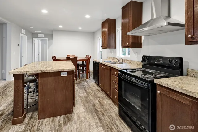 a kitchen with stainless steel appliances granite countertop a stove a sink and a microwave