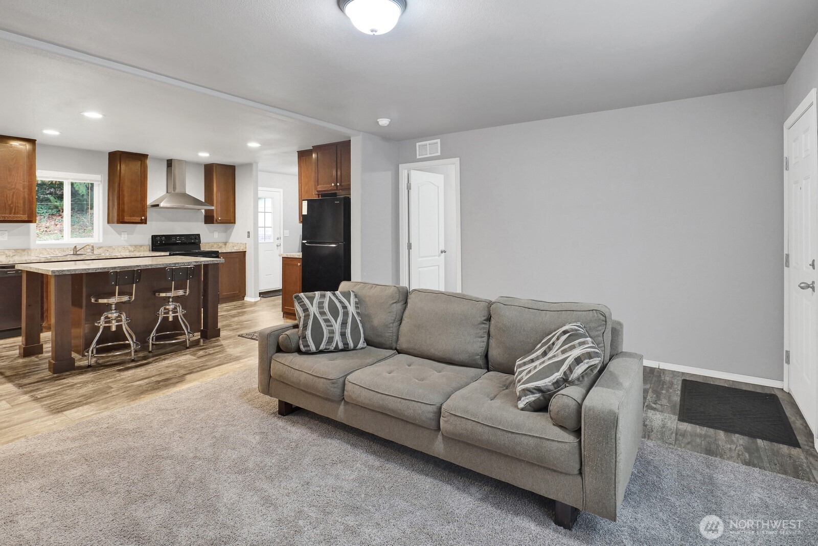 467 Cain Lake Road Sedro-Woolley, WA 98284 - Photo 5 of 28 a living room with furniture a fireplace and kitchen view