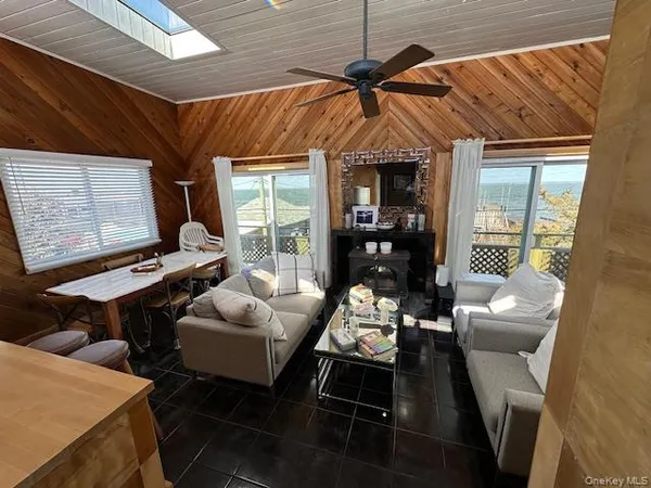 a living room with furniture a ceiling fan and a window