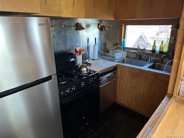 a kitchen with stainless steel appliances a refrigerator a sink a stove and a refrigerator