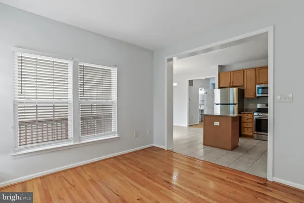 a view of kitchen with kitchen island wooden floor and electronic appliances