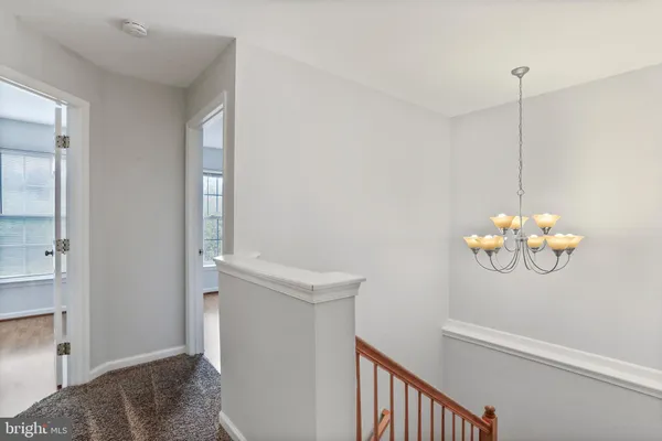 a view of a room with a chandelier fan