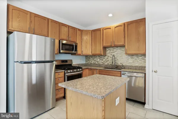 a kitchen with stainless steel appliances granite countertop a refrigerator stove microwave and sink