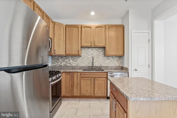 a kitchen with stainless steel appliances granite countertop refrigerator sink and cabinets