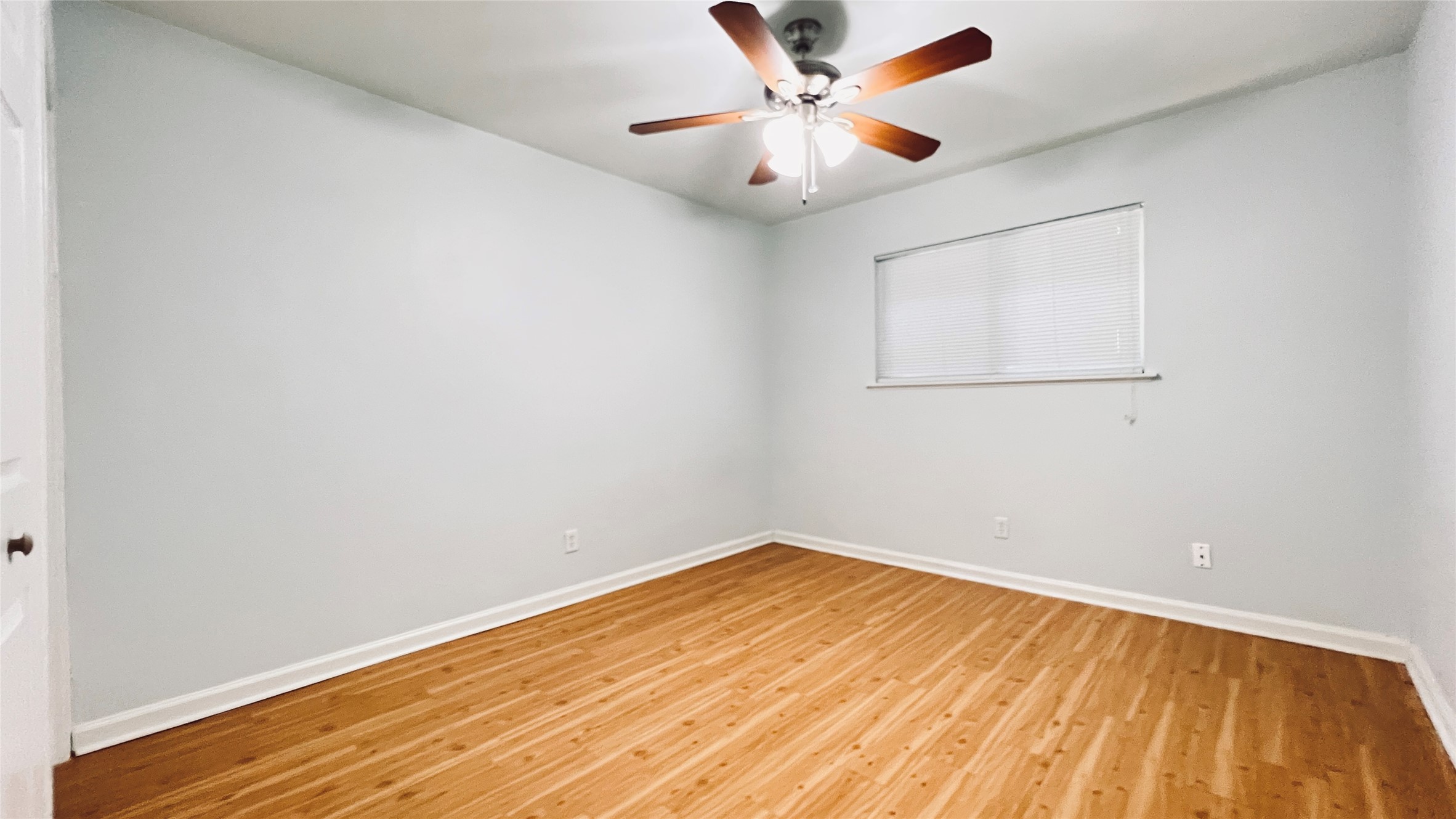 2301 Ohlen Road, Unit 209 Austin, TX 78757 - Photo 4 of 10 A quiet bedroom featuring hardwood flooring and a cooling ceiling fan.