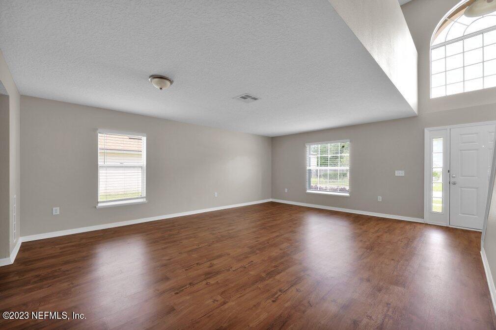 12070 Chester Creek Road Jacksonville, FL 32218 - Photo 11 of 45 an empty room with wooden floor and windows