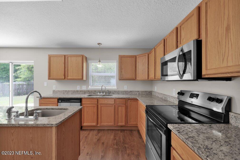 12070 Chester Creek Road Jacksonville, FL 32218 - Photo 16 of 45 a kitchen with stainless steel appliances granite countertop a sink stove and cabinets