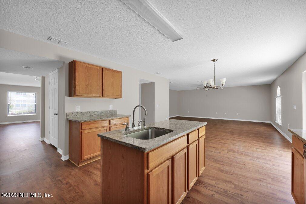 12070 Chester Creek Road Jacksonville, FL 32218 - Photo 18 of 45 a kitchen with granite countertop a sink stove and cabinets