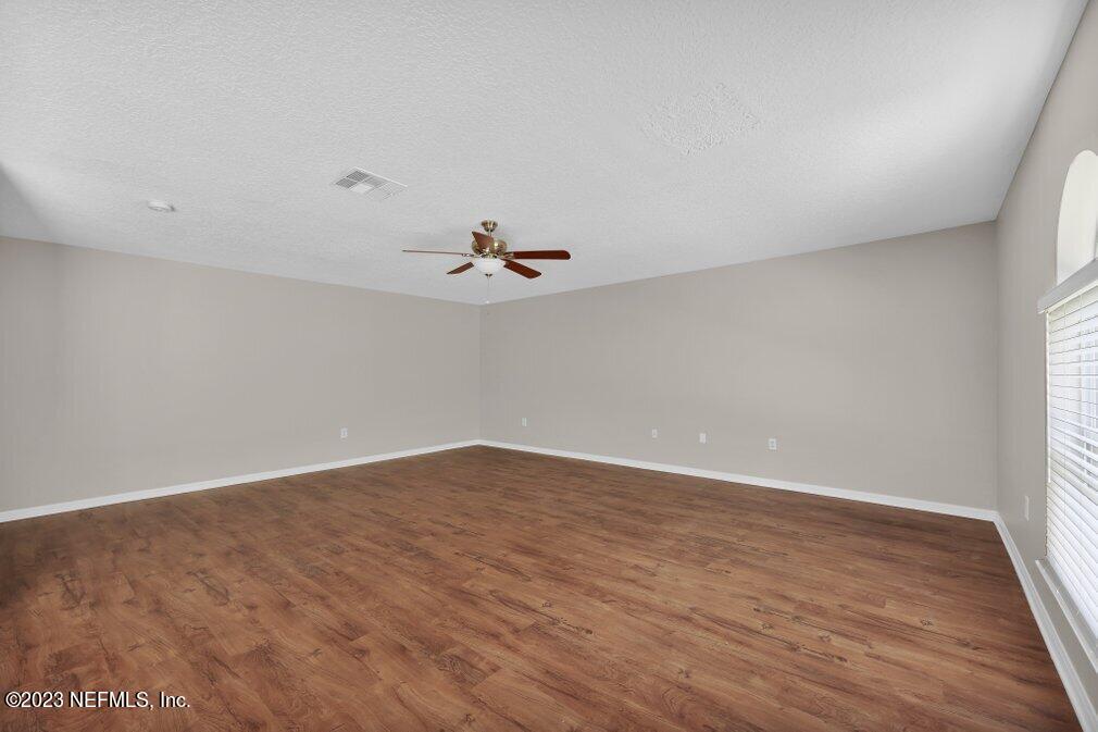 12070 Chester Creek Road Jacksonville, FL 32218 - Photo 19 of 45 an empty room with wooden floor and fan