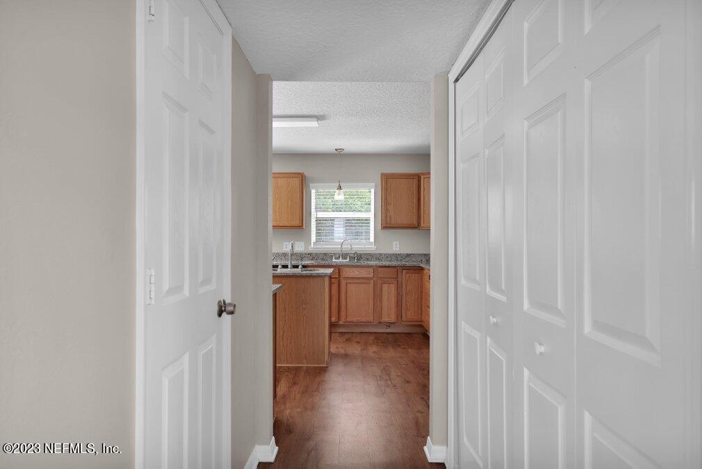 12070 Chester Creek Road Jacksonville, FL 32218 - Photo 23 of 45 a view of a hallway with wooden floor and a bathroom